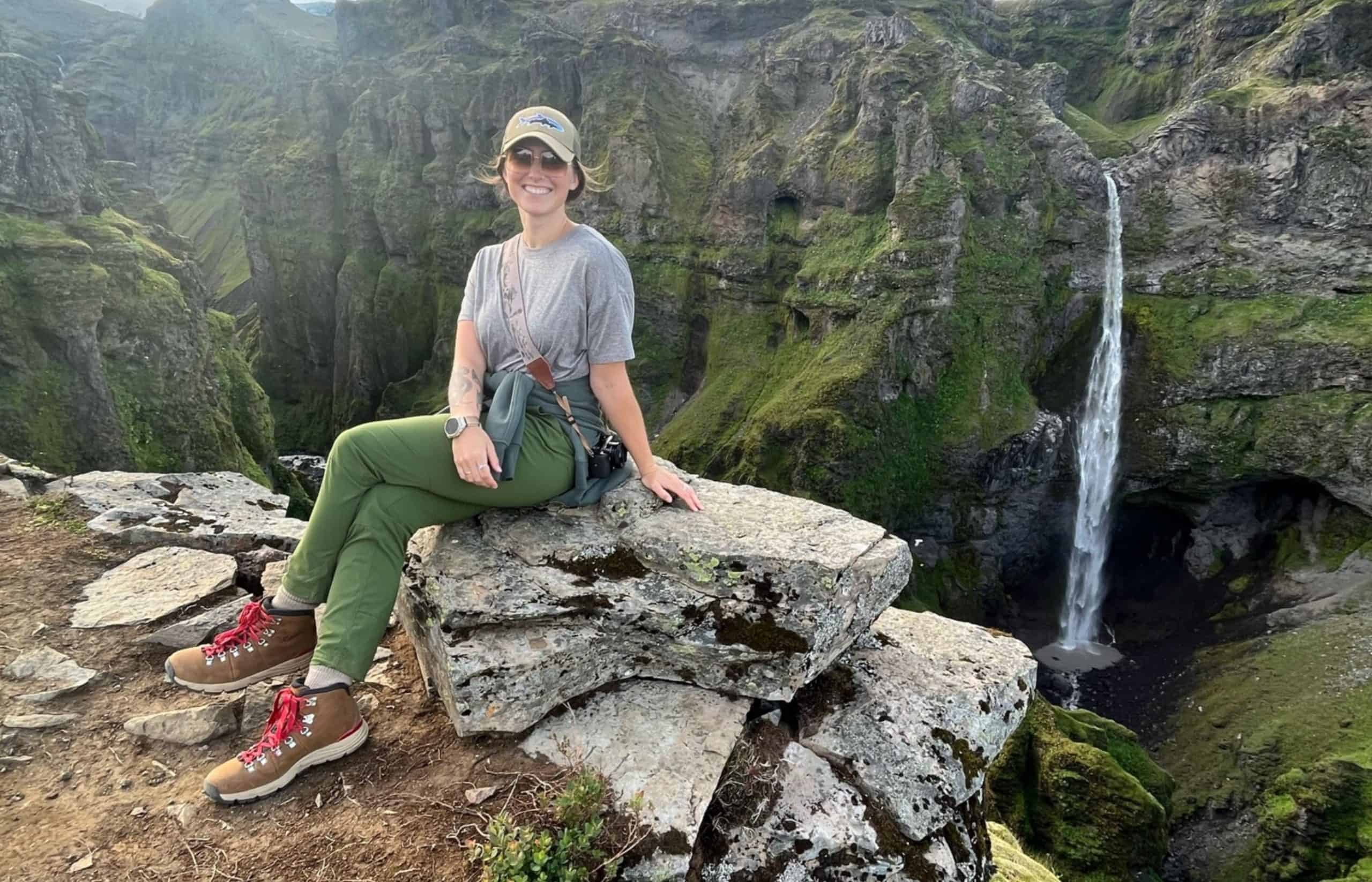 A woman wearing her REI pants in Iceland on an epic hike with waterfalls in the background.