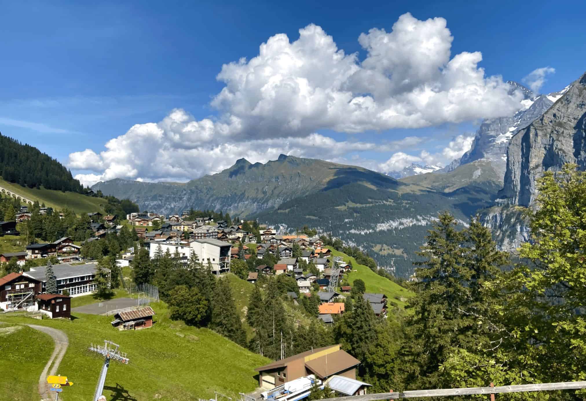 A view of the town of Murren on a sunny day and a pathway that goes into the town.