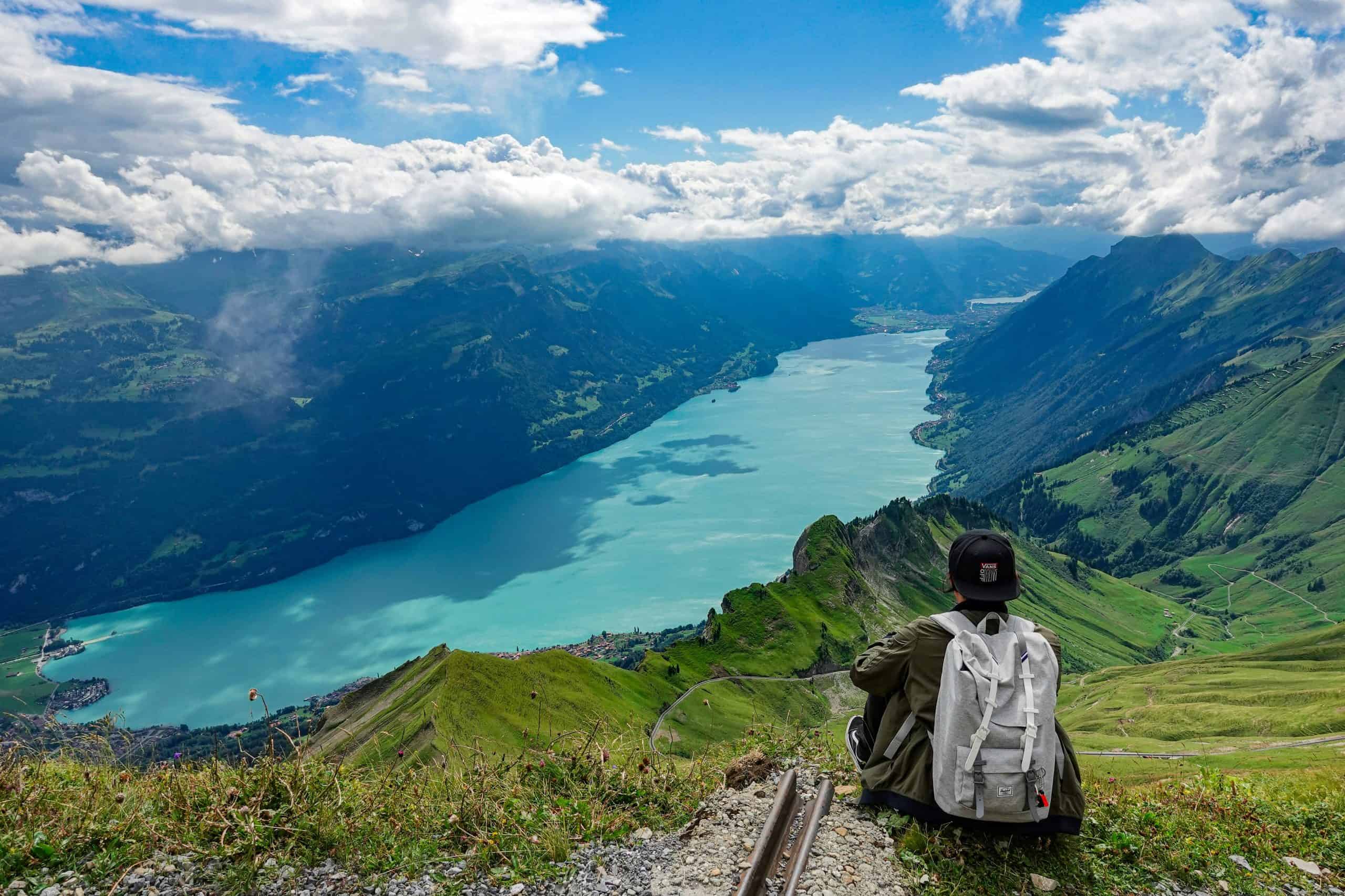 A man overlooking the valley and lake in Interlaken on a beautiful late summer day. This is one of the main reasons that people enjoy Interlaken. It is well known for being the capital of adventure in Switzerland.
