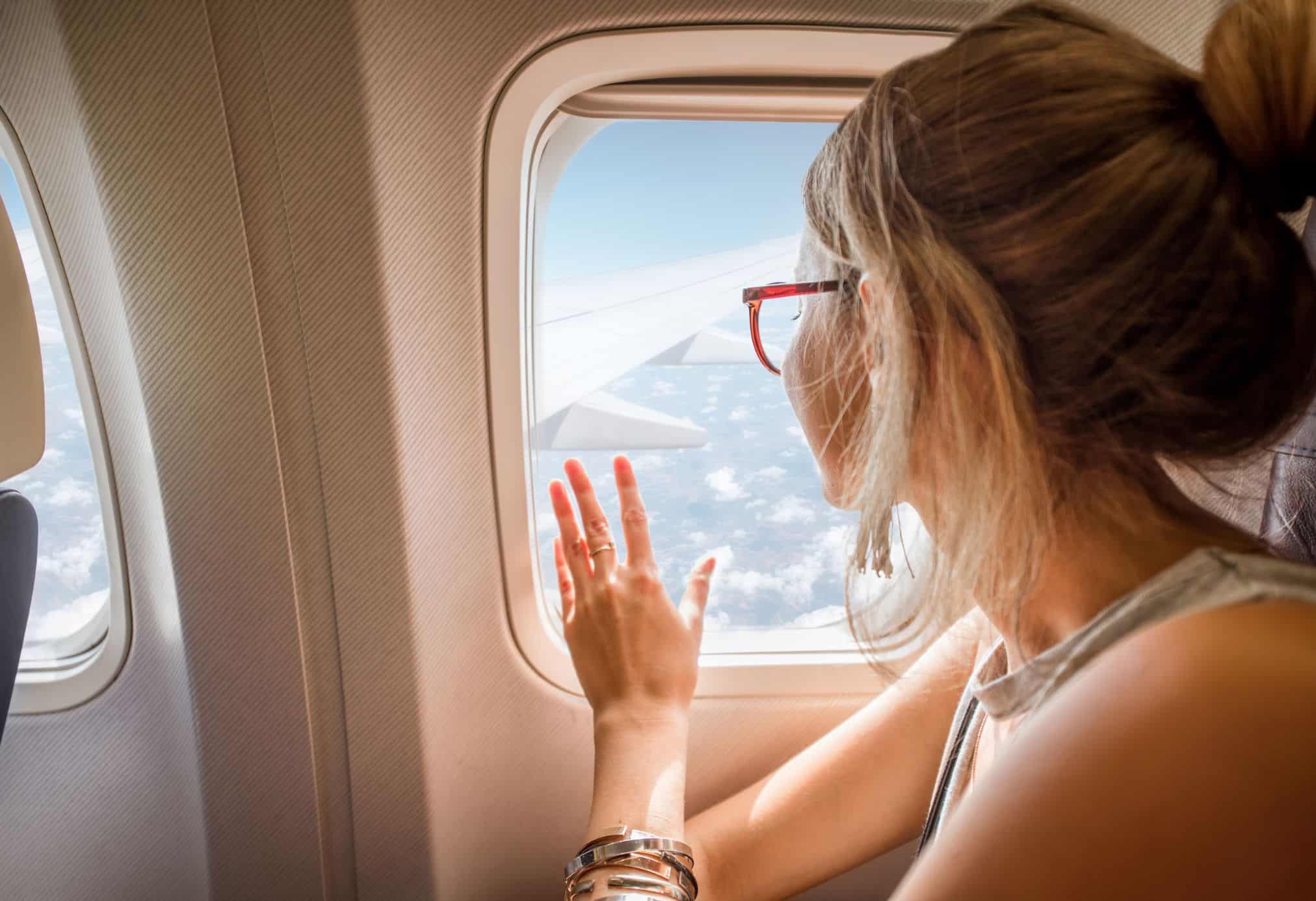 A woman sitting in Delta plane on a beautiful sunny day.