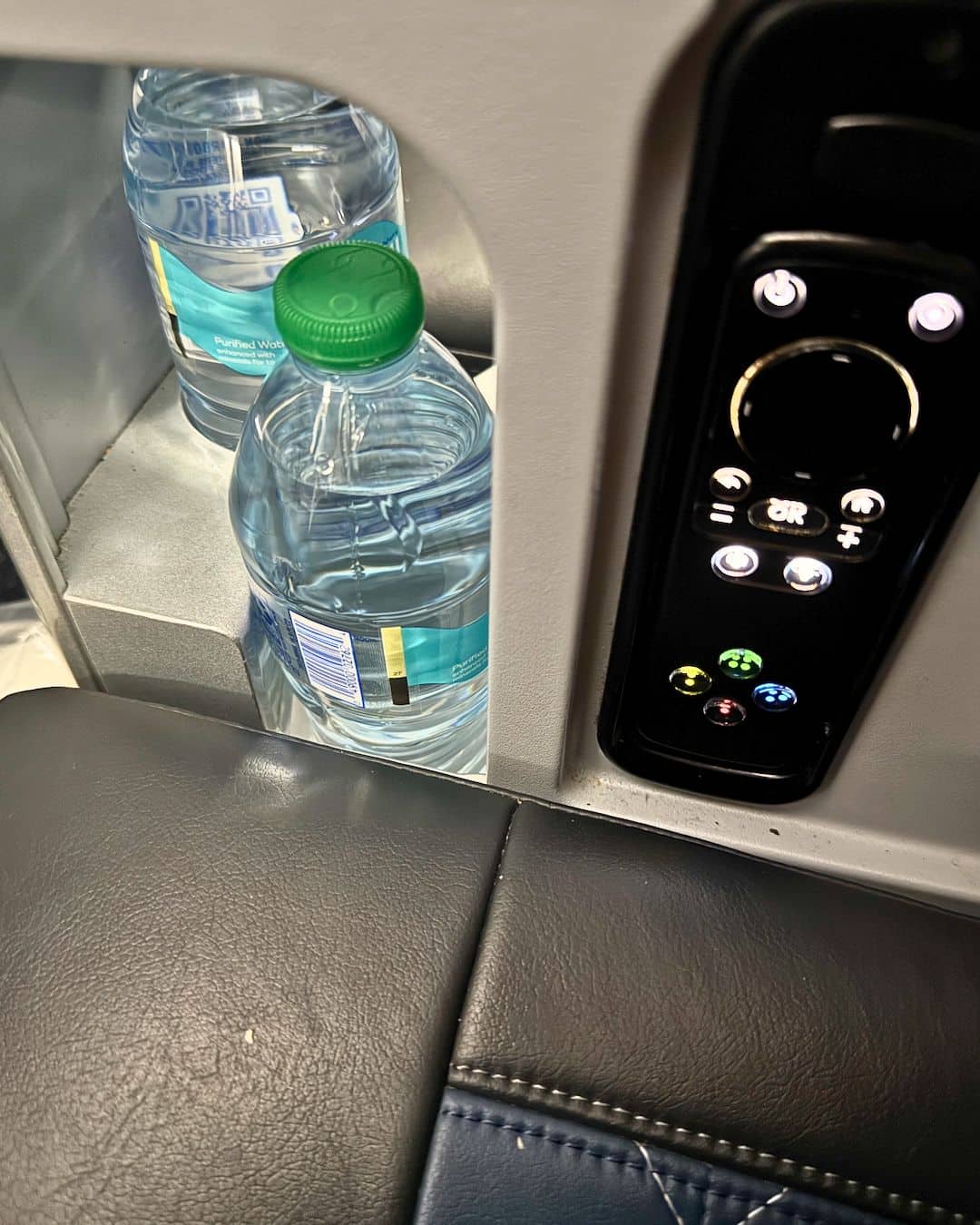 The water that is included in this upgraded seat on a Delta flight included with a remote for entertainment.