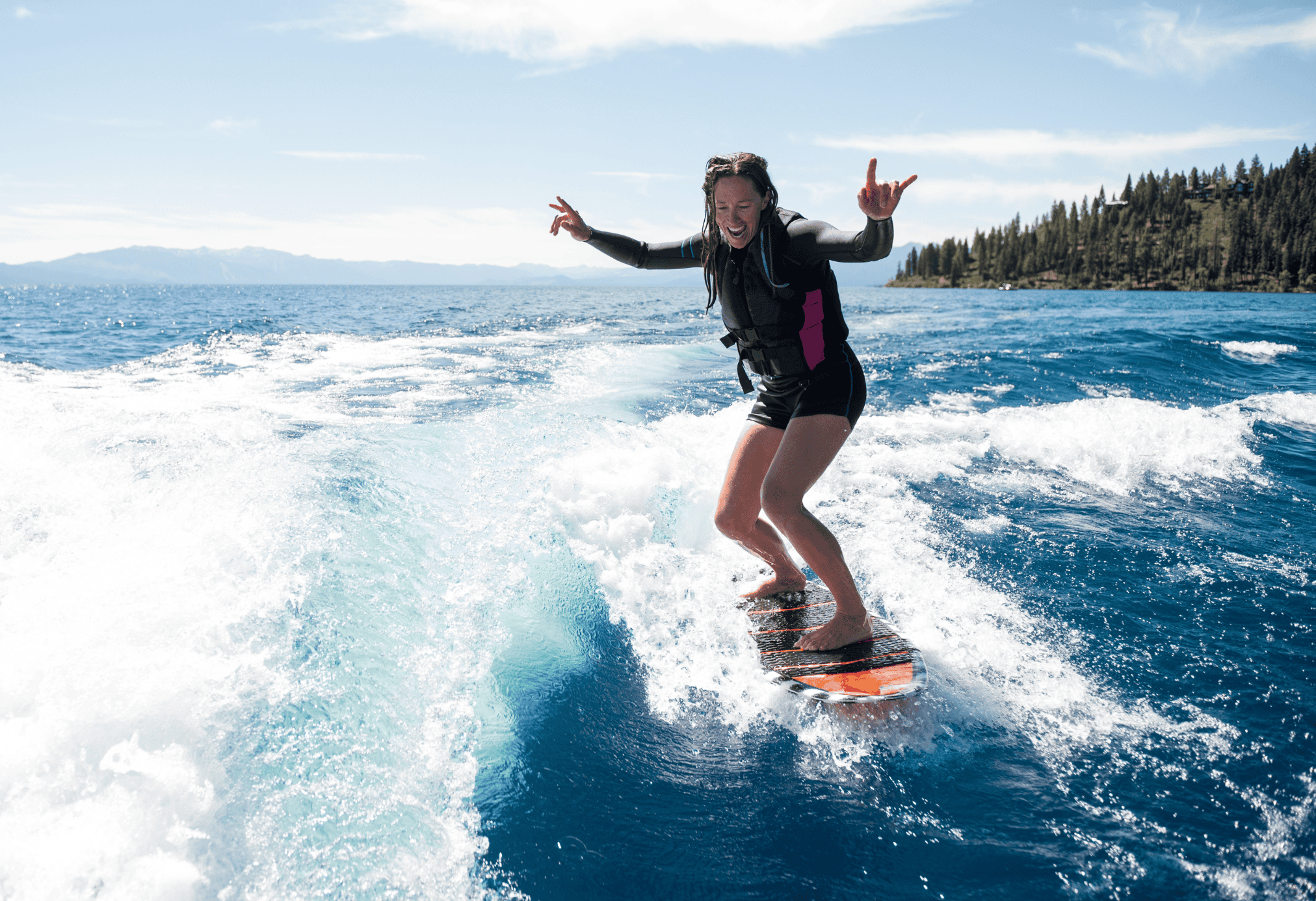 A woman wakesurfing on Lake Zurich on a sunny day in the summer.
