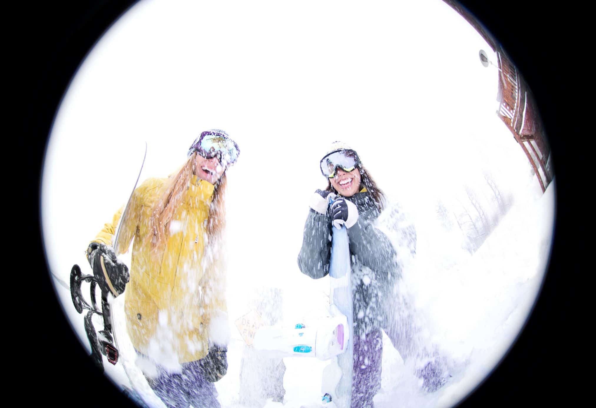 Two girls taking a photo during a ski day on a mountain in Switzerland.