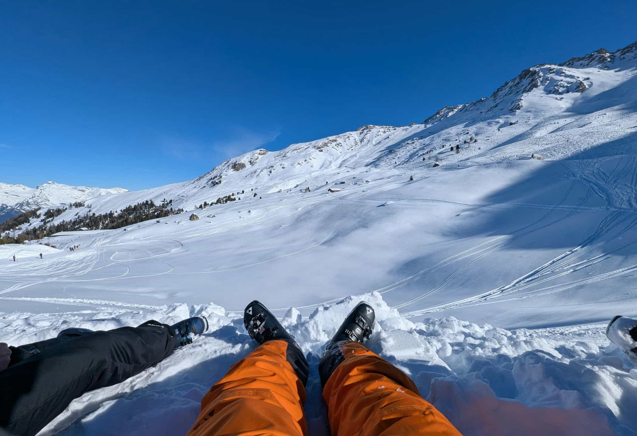 Two friends sitting in the snow for a day of skiing outside of Interlaken.