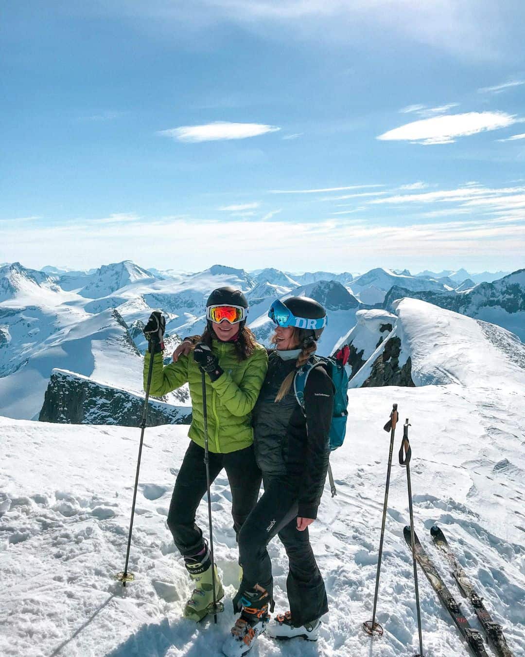 Two women laughing at the top of a mountain for skiing in Interlaken in the winter.